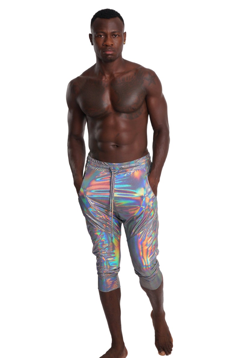 Puede incluir: Un hombre con pantalones plateados iridiscentes con cintura de cord&oacute;n. Los pantalones son cortos y tienen un ligero brillo.