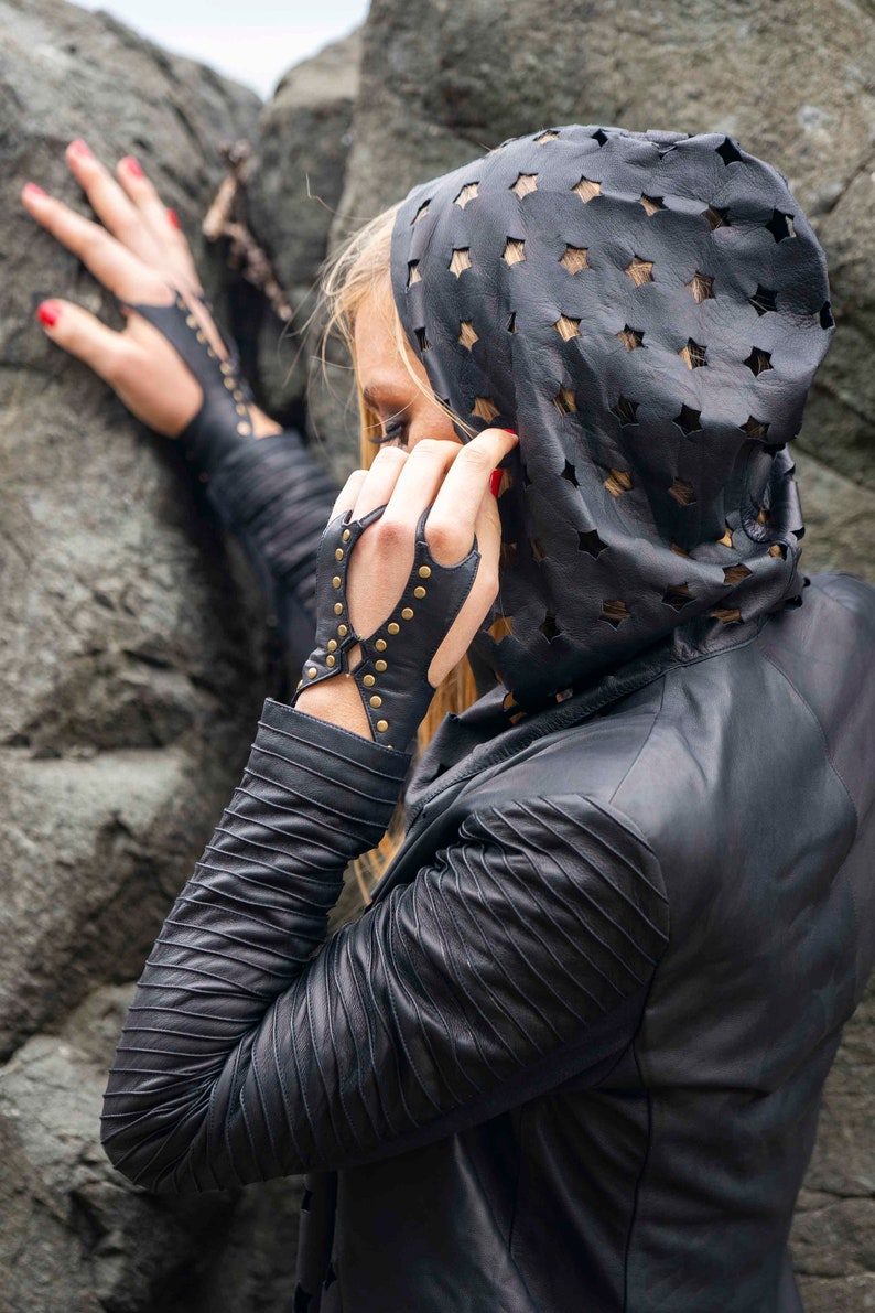 Soft black leather hand bracelet embellished with metal studs and wrist metal buttons to fasten. Black fingerless gloves, festival wear punk, emo, and rock n roll style accessories.