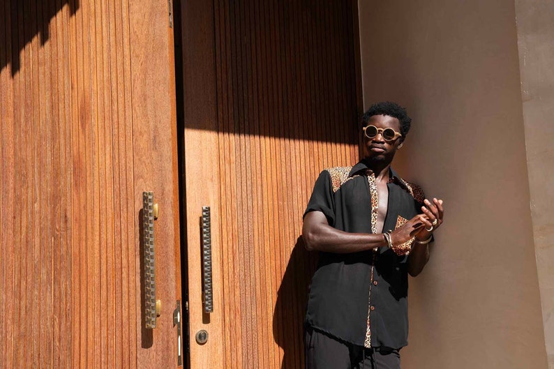 man wearing a black and leopard print button down shirt from Love Khaos