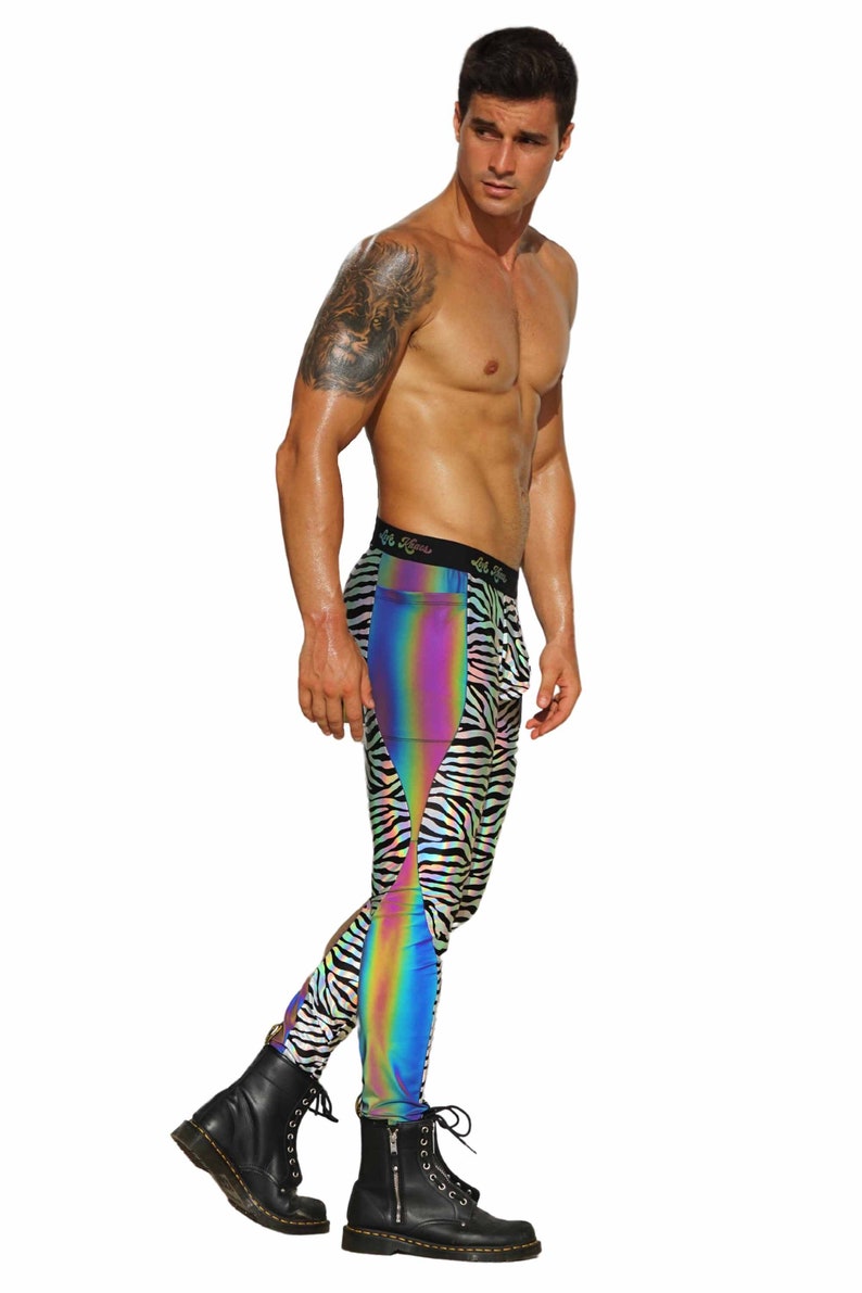 May include: A person wearing black and white zebra print leggings with a rainbow iridescent panel on the side. The leggings have a black waistband with the text "Let's Move" printed on it. The person is wearing black boots.