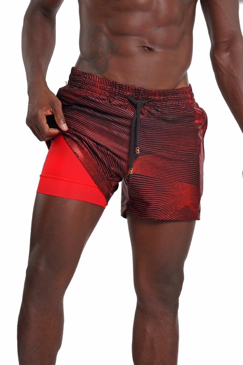 May include: Red and black athletic shorts with a striped pattern. The shorts have a built-in liner.