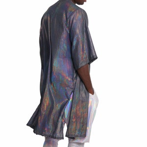 K&ouml;nnte beinhalten: Ein lang&auml;rmeliges, irisierendes Hemd mit schwarzer Basis und holografischem Finish. Das Hemd hat eine lockere Passform und eine etwas l&auml;ngere L&auml;nge. Das Model tr&auml;gt das Hemd mit einer irisierenden Leggings.