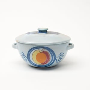 May include: A light blue ceramic serving dish with a lid. The dish has two handles and a blue and white design with a stylised orange fruit.