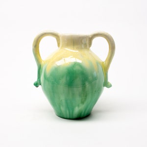 May include: A two-handled ceramic vase with a colour gradient. The top is pale yellow, transitioning to a vibrant green at the base. The vase has a classic amphora shape, suitable for home decor.