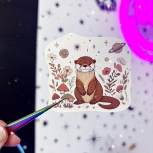 Sticker loutre lunatique - sticker loutre des bois - sticker loutre magique fleurs sauvages - sticker loutre enchantée magique - sticker céleste