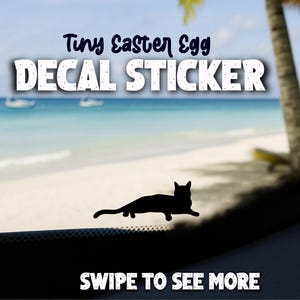 May include: A black cat silhouette decal sticker with the text "Tiny Easter Egg DECAL STICKER" in white and blue. The background shows a beach scene with the text "SWIPE TO SEE MORE".