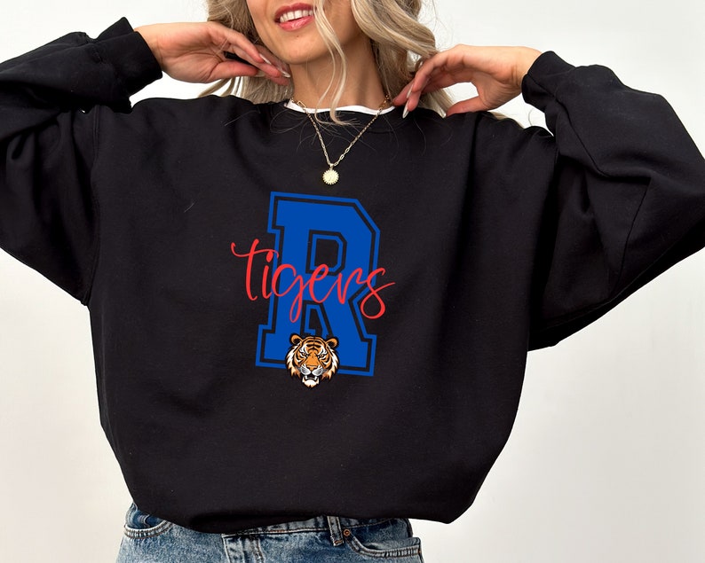 May include: Black sweatshirt with a blue and white letter "R" and the word "Tigers" in red. A tiger head is inside the letter "R".