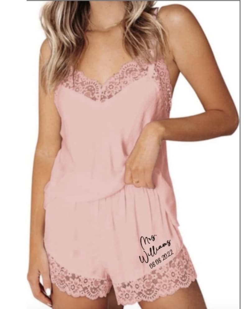 May include: Pink satin pajama set with lace trim. The shorts have the text "Mrs. Williams 08.08.2022" printed on them.