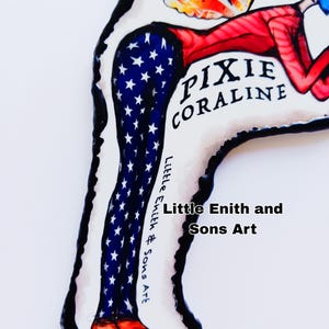 May include: A whimsical art piece featuring a stylized figure with blue hair and red clothing. The figure's legs are adorned with a blue and white star pattern, and the text "PIXIE CORALINE" is visible. The artwork is signed "Little Enith and Sons Art."