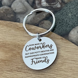 May include: Silver keychain with a round tag that says "Work made us coworkers but our potty mouths and inappropriate conversations made us friends".