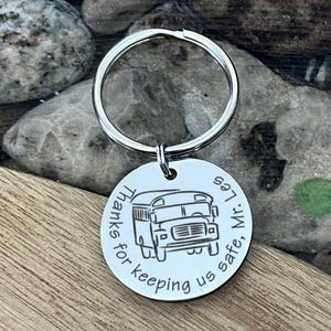 May include: Silver keychain with a round tag that says "Thanks for keeping us safe, Mr. (bus icon)  #7".