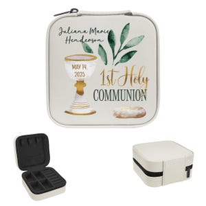 May include: A white, square jewelry case with a black zipper and handle. The case is decorated with a gold chalice, greenery, and the text "1st Holy Communion." The name "Juliana Marie Henderson" and the date "May 14, 2025" are also printed on the case.
