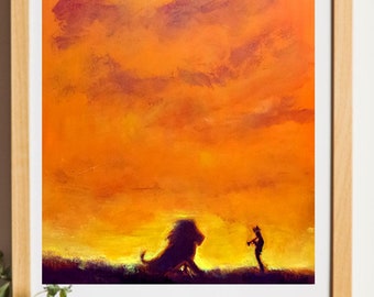 Op de afbeelding: Ingelijste kunstafdruk met een silhouet van een leeuw en een figuur tegen een levendige oranje en gele zonsondergang. Het kunstwerk wordt getoond op een houten oppervlak met een vintage camera, een witte kan met groen en een kleine cactus in een terracotta pot.