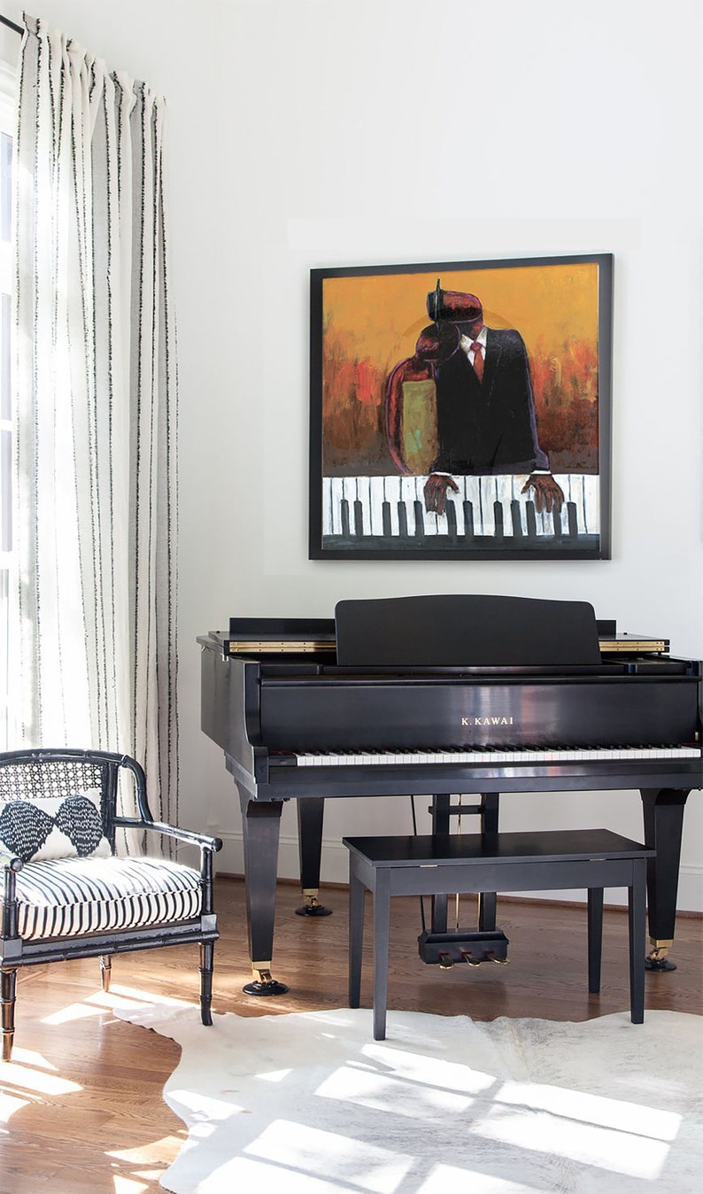 Op de afbeelding: Een zwarte vleugelpiano met een zwarte pianokruk er voor. De piano heeft een gouden inscriptie met de tekst "K. Kawai". Een wit koeienhuidkleed ligt op de vloer voor de piano. Een zwart-wit gestreepte stoel met een zwarte rieten rugleuning staat op de achtergrond. Een ingelijst schilderij van een persoon die piano speelt, hangt aan de muur boven de piano.