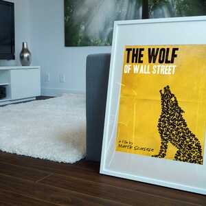 Pode incluir: Um p&ocirc;ster emoldurado branco com fundo amarelo e uma silhueta de lobo preta feita de sinais de d&oacute;lar. O p&ocirc;ster diz "The Wolf of Wall Street" e "Um filme de Martin Scorsese".
