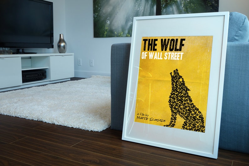 Pode incluir: Um p&ocirc;ster emoldurado branco com fundo amarelo e uma silhueta de lobo preta feita de sinais de d&oacute;lar. O p&ocirc;ster diz "The Wolf of Wall Street" e "Um filme de Martin Scorsese".
