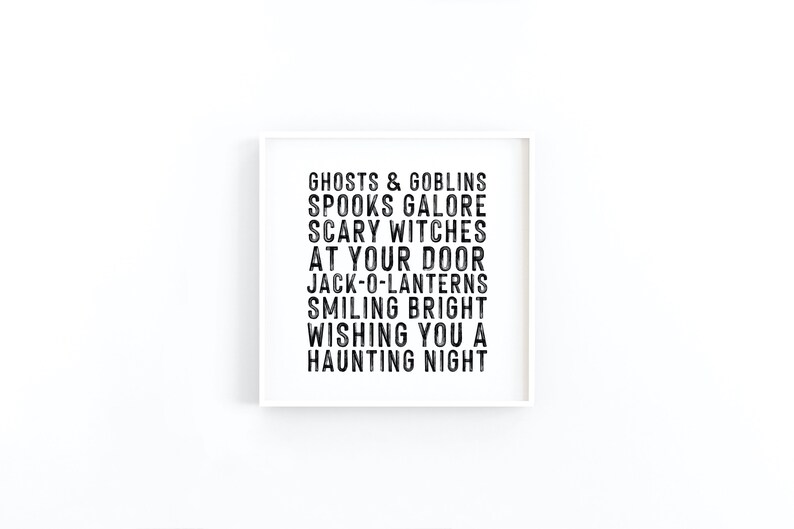 May include: A white framed print with black text that reads "Ghosts & Goblins, Spooks Galore, Scary Witches, At Your Door, Jack-O-Lanterns, Smiling Bright, Wishing You A Haunting Night."