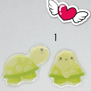 May include: Two green and yellow turtle stickers with smiling faces. The turtles have a green shell with white dots and green legs.