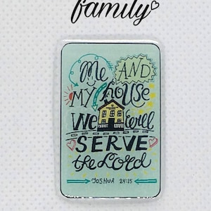 May include: A teal blue square sign with a white border and a house illustration. The sign reads "Me and my house we will serve the Lord" with a heart around the word "serve". The bottom of the sign reads "Joshua 24:15".