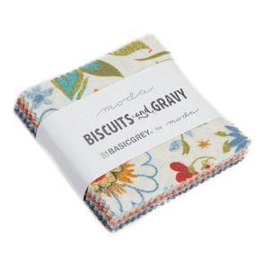 May include: A stack of fabric squares with floral patterns in red, blue, yellow, and green. The fabric is wrapped with a white band that reads "BISCUITS and GRAVY" and "moda" in a script font.