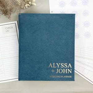 Personalized wedding planner binder to organize your entire wedding in one place — includes all checklists, timelines, budget sheets, and vendor contract sections. Fully customizable cover and spine colors with your names, wedding date, or custom text. Perfect keepsake for brides and wedding planners to stay organized from engagement to wedding day.