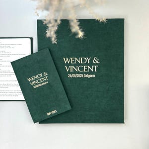 May include: A dark green wedding vow book and matching booklet. The book and booklet feature the names "WENDY & VINCENT" and the date "24/08/2025 Galgorm" in a white, elegant font. The booklet is labelled "OUR VOWS".