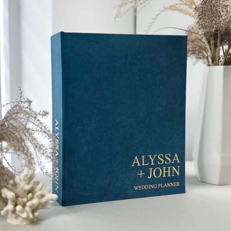 Personalized wedding planner binder to organize your entire wedding in one place — includes all checklists, timelines, budget sheets, and vendor contract sections. Fully customizable cover and spine colors with your names, wedding date, or custom text. Perfect keepsake for brides and wedding planners to stay organized from engagement to wedding day.
