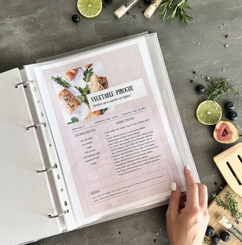 Recipe binder page featuring a vegetable pirogue recipe.  The page is off-white with pink accents.  The recipe title is in a serif font. Ingredients include butter, eggs, cocoa, and baking soda.  Cooking time is 30 minutes.  Prep time is 15 minutes.  A photo of the finished vegetable pastries is included.