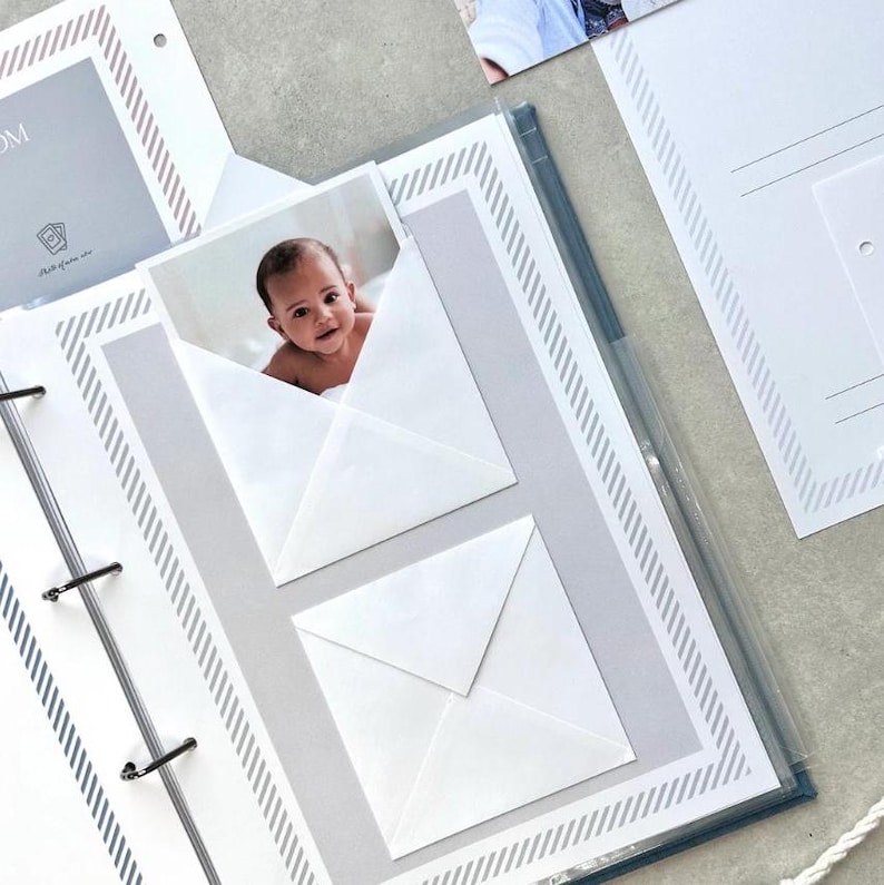 Inside pages of a handmade baby memory book binder created for capturing milestones and photo memories. Each page includes space for firsts like smiles, steps, birthdays, and family moments. The soft, minimal design allows parents to easily add, remove, and rearrange pages as their baby grows. Designed with photo areas and prompts for notes, this keepsake binder helps preserve every special moment from birth through the early years in a beautiful, organized way.