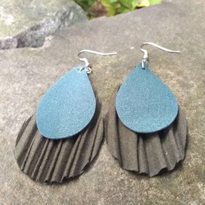 May include: Teal and brown layered teardrop earrings with silver hooks.
