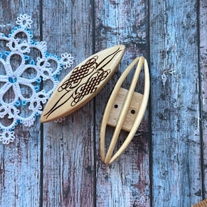 Puede incluir: Dos bobinas de madera para hacer encaje. Una es lisa y la otra tiene un diseño decorativo.