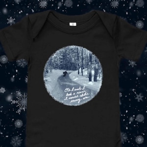 May include: Black baby bodysuit with a circular winter scene print. The print features a snowy path through a forest with the text "Oh I wish I had a river I could skate away on."