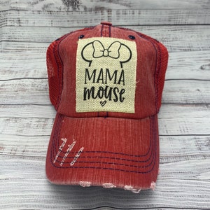 May include: Red distressed baseball cap with a white patch that says "Mama Mouse" with a black outline of Mickey Mouse ears and a bow on top.