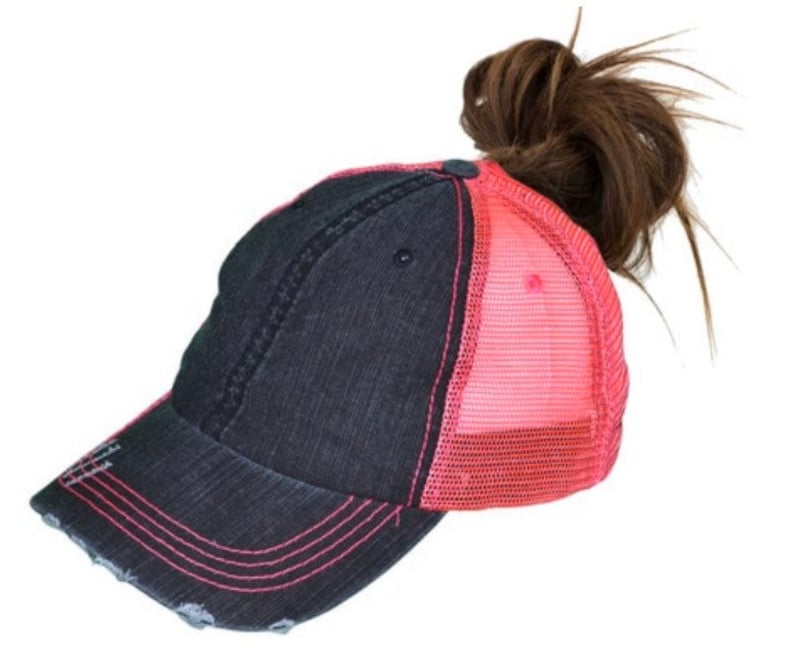 May include: A black and pink distressed baseball cap with a mesh back. The cap has a ponytail hole in the back.