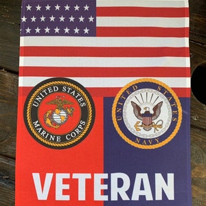 May include: A red, white, and blue American flag with the words "United States Marine Corps" and "United States Navy" in gold circles below. The words "Veteran" are printed in white below the circles.