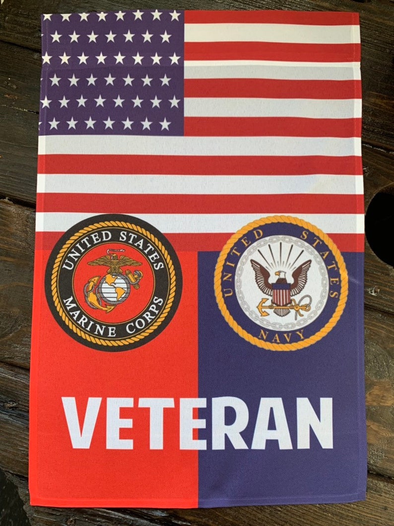 May include: A red, white, and blue American flag with the words "United States Marine Corps" and "United States Navy" in gold circles below. The words "Veteran" are printed in white below the circles.