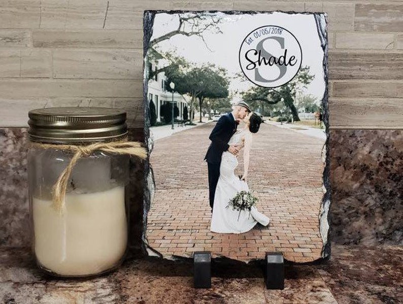 May include: A black slate plaque with a photo of a couple kissing. The plaque has a white circle with the text "Est. 01/05/2018 Shade" in black.
