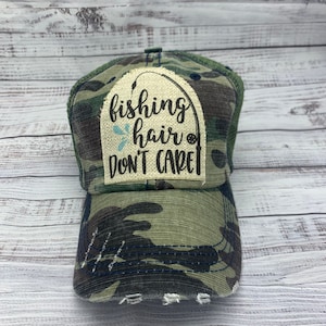 May include: A camouflage trucker hat with a patch that says "fishing hair don't care".