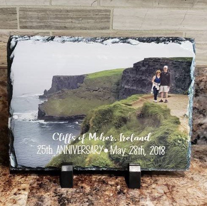 May include: A slate photo plaque with a photo of a couple standing on a cliff overlooking the ocean. The text "Cliffs of Moher, Ireland 25th Anniversary - May 28th, 2018" is printed on the plaque.
