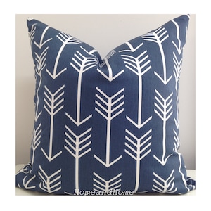 Puede incluir: Una almohada azul con un patrón de flechas blancas. La almohada está hecha de una tela suave y duradera y es perfecta para agregar un toque de estilo a cualquier habitación.