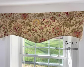 May include: A window valance featuring a beige fabric base with a multi-colored floral pattern in shades of yellow, red, and green. The valance has a scalloped bottom edge and includes the text GOLD HomeandHome printed on the right side.