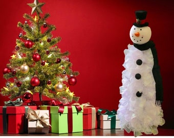 May include: A white snowman decoration with a black top hat and scarf, standing next to a decorated Christmas tree with red and gold ornaments. There are wrapped gifts in the foreground.
