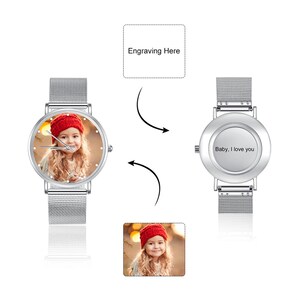 K&ouml;nnte beinhalten: Eine silberne Armbanduhr mit einem Mesh-Armband. Das Zifferblatt zeigt ein Farbfoto eines Kindes mit roter M&uuml;tze. Auf der R&uuml;ckseite der Uhr steht "Baby, I love you".