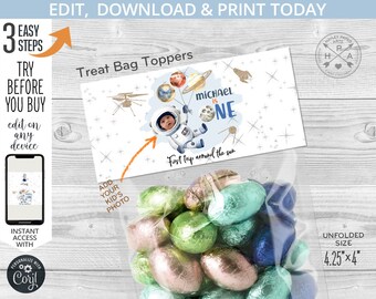 May include: A treat bag topper with an astronaut theme, featuring the text "MICHAEL IS ONE" and "First trip around the sun." The design includes planets, stars, and an astronaut. The unfolded size is 4.25" x 4".