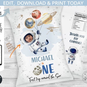 May include: A printable party favour bag design featuring a cartoon astronaut holding balloons with planets. The bag is decorated with stars and the text "Michael is One, First trip around the Sun".