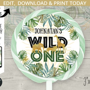 May include: A green and gold round lollipop wrapper with a jungle theme. The text "Johnatan's Wild One" is printed in black and gold letters. The wrapper is 3 inches by 3 inches.