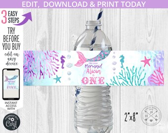 May include: Water bottle label with a mermaid theme. The label is pink, blue, and green with a mermaid tail, seashells, and coral. The text on the label reads "Our little Mermaid Alicia is ONE". The label is 2 inches by 8 inches.