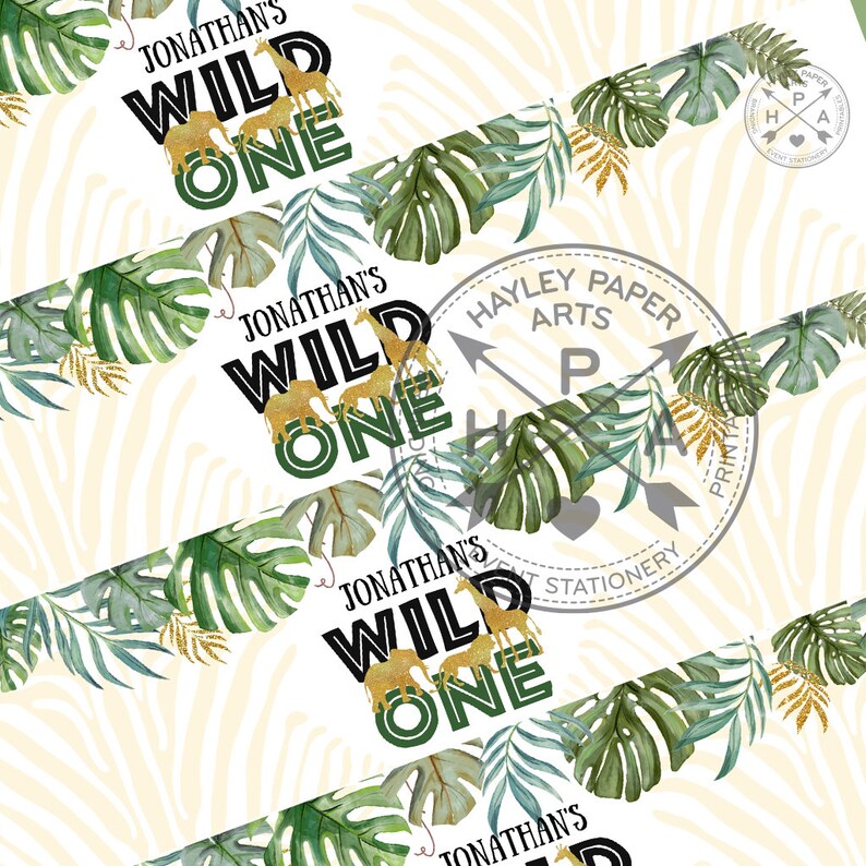 Op de afbeelding: Een printbare banner met een jungle thema. De banner zegt "Jonathan's Wild One" in zwarte tekst met gouden en groene accenten. De banner is versierd met groene bladeren en gouden glitter.