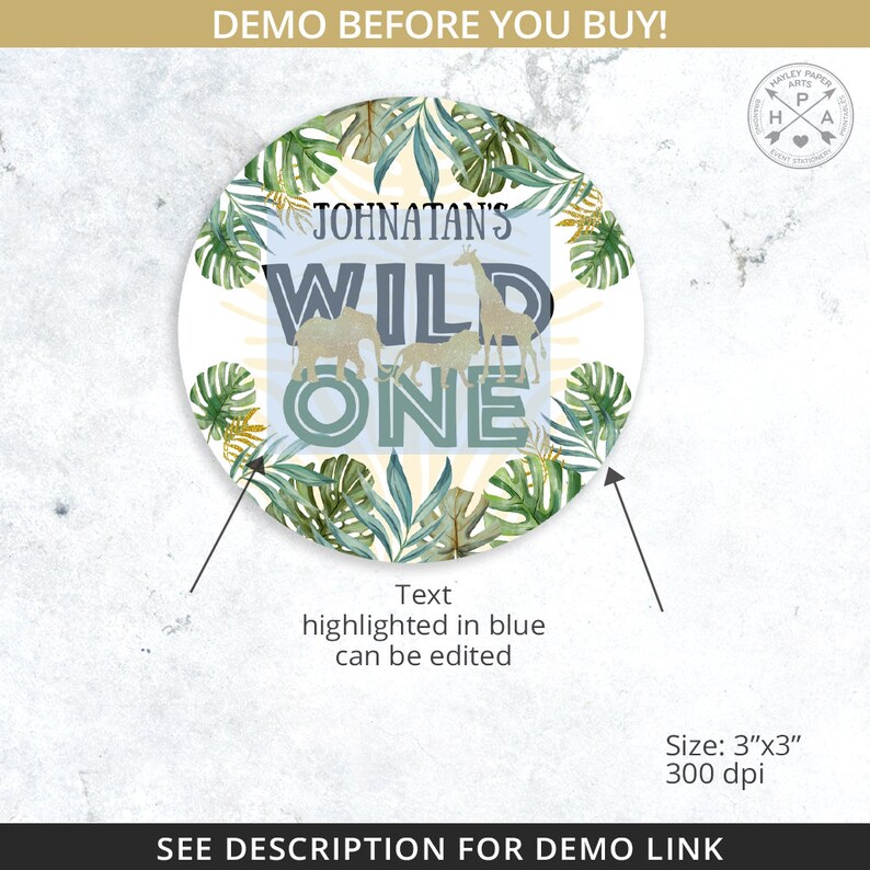 May include: A round, white sticker with a jungle theme. It features a green and gold leafy design with a giraffe, elephants, and the text "Johnatan's Wild One" in blue and gold.