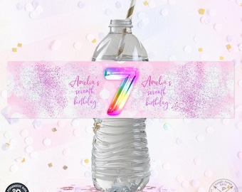 Puede incluir: Etiqueta de botella de agua rosa y blanca con purpurina con un número 7 arcoíris y el texto "Amelia's seventh birthday".